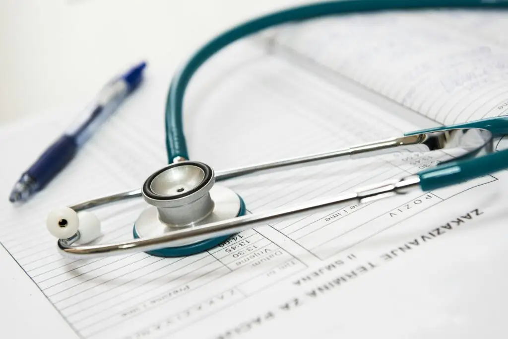 Stethoscope placed on top of medical forms and a clipboard